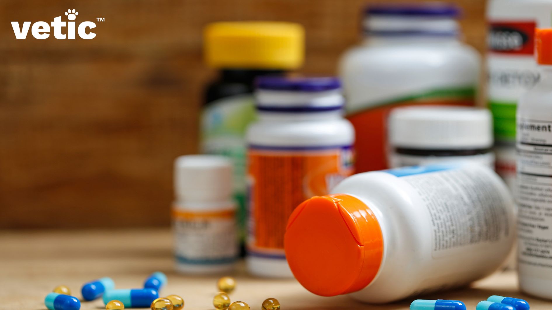 A number of bottles of medicines and supplements. Some blue and translucent yellow pills on the ground. Could be supplements for dogs or vitamins.
